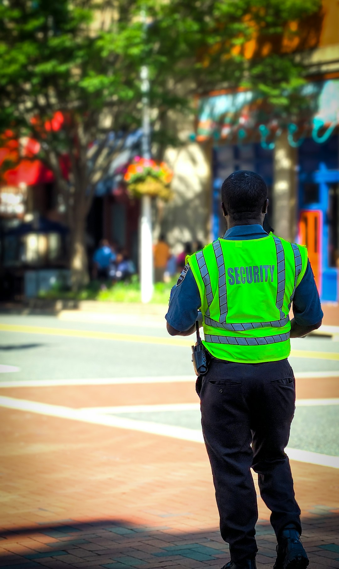 Security Guard in a neon green vest watches over a 4way intersection in Shirlington VA.nI miss counted the men Liz!